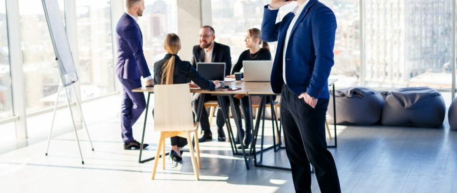 Business people, businessmen are working together in a modern office in a multi-storey skyscraper. The director is on the phone. Office work concept. Selective focus